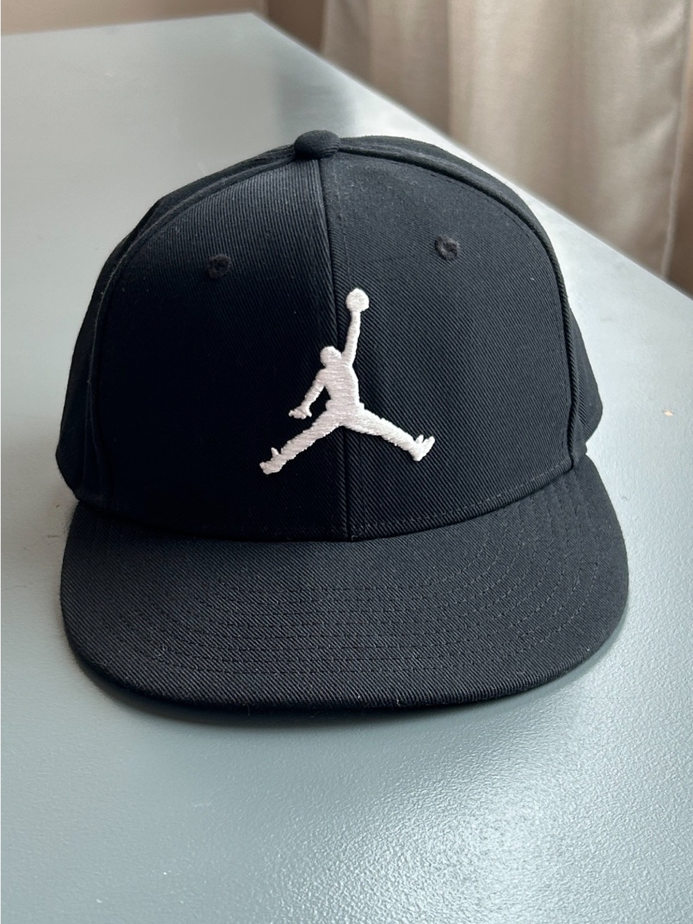 Jordan Men’s Pro Jump-man Black Snapback Hat with White Embroidered Logo. Small.